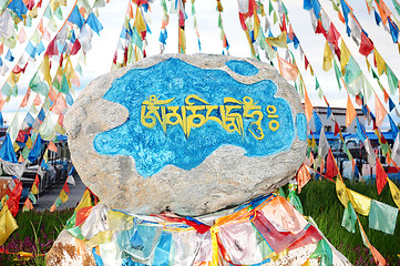 Image showing Tibetan prayer flags and mani rock