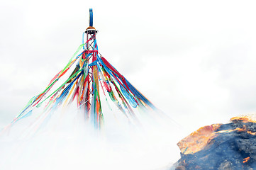 Image showing Tibetan prayer flags and mani rock in the smoke