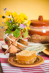 Image showing Still life with honeycombs, flowers and pot 