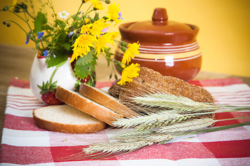 Image showing Still life with bread, flowers and pot