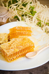 Image showing honeycomb with daisies on white plate 