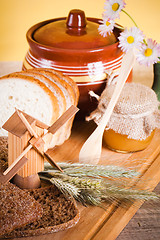 Image showing honey, flowers, spike and bread on table 