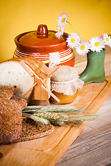 Image showing sliced bread and wheat on the wooden table 