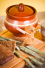 Image showing sliced bread and wheat on the wooden table 