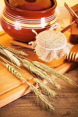 Image showing sliced bread and wheat on the wooden table 