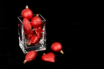 Image showing Red Christmas ornaments in and around a glass vase