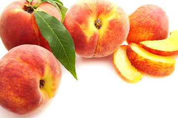 Image showing  Fruits of peach with green leaves.