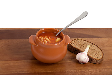 Image showing Soup in ceramic pot with bread and garlic