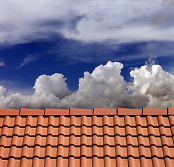 Image showing Roof tiles and blue sky with clouds