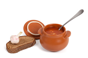 Image showing Borsch in clay pot with bread and garlic