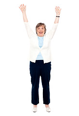 Image showing Excited senior woman posing with raised arms