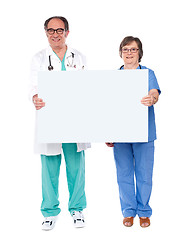 Image showing Aged doctors displaying white billboard