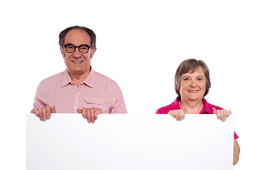 Image showing Aged couple displaying blank billboard