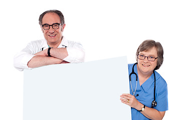 Image showing Two matured doctors holding white banner ad
