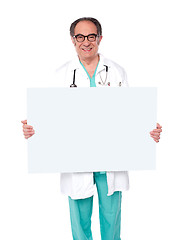 Image showing Male doctor posing with white blank billboard