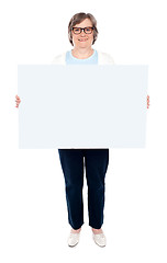 Image showing Smiling old lady holding blank whiteboard