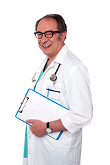 Image showing Senior male doctor holding blank clipboard