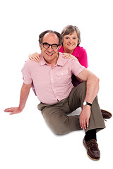 Image showing Smiling senior couple seated on floor. Posing