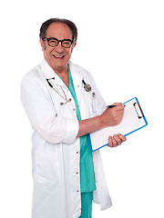 Image showing Senior surgeon writing medical report