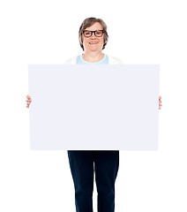Image showing Aged woman displaying blank poster