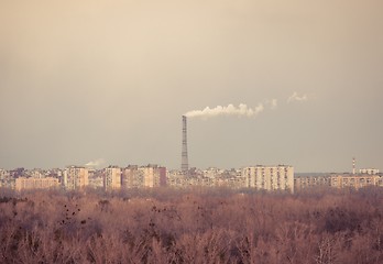 Image showing Big chimney in the middle of a city with sky