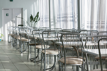 Image showing Photo of a canteen with metal chairs and tables