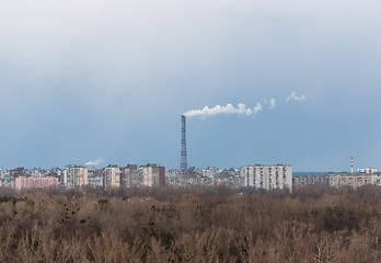 Image showing Big chimney in the middle of a city with sky
