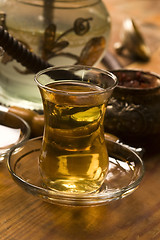 Image showing Cup of turkish tea and hookah served in traditional style