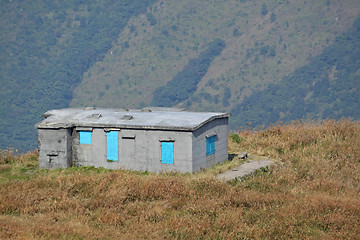 Image showing old stone house with grass on the mountain 