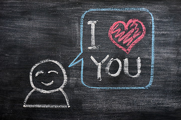 Image showing Speech bubble with a cartoon figure, saying I love you drawn on a blackboard background