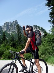 Image showing Mountainbiker looking up at mountain