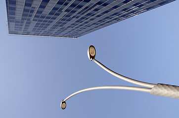 Image showing High glass building and street lights in blue sky 