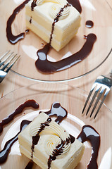 Image showing fresh cream cake closeup with chocolate sauce