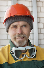 Image showing An elderly worker in protective helmet