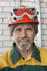 Image showing An elderly worker in protective helmet