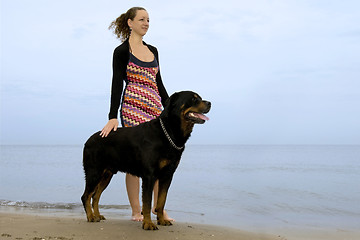 Image showing rottweiler and woman on the beach