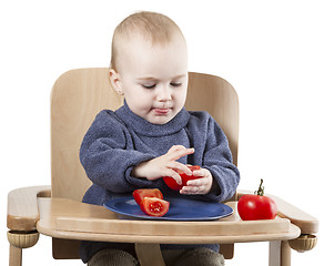 Image showing young child eating in high chair