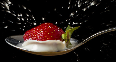 Image showing red, ripe strawberry falling in spoon with milk