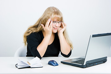 Image showing Smiling blonde looks at the monitor