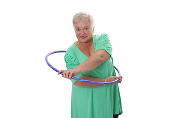 Image showing Senior lady doing gymnastic with hula-hoop