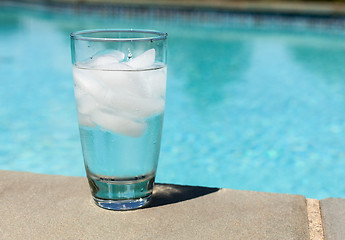 Image showing Glass of water with ice cubes on side of pool