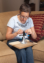 Image showing Lady jeweller making pendant