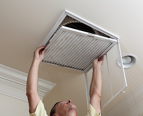 Image showing Senior man opening air conditioning filter in ceiling