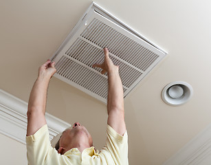 Image showing Senior man opening air conditioning filter in ceiling