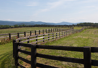 Image showing Rolling meadows with wooden fences and hills