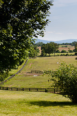 Image showing Rolling meadows with wooden fences and hills