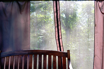 Image showing Summerhouse bench and view through net to nature 