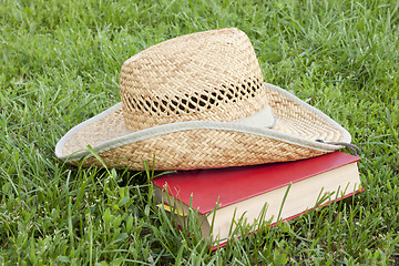 Image showing Straw hat with a book