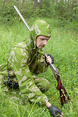 Image showing Hunter with an old rifle is considering the trail