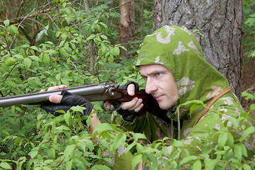 Image showing The shooter in camouflage with an old gun